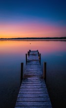 Beautiful Shot Of Sunset Colors In The Horizon Of A Tranquil Lake With A Dock