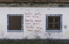 Beautiful Shot Of A White Old Building With Broken Windows And Red Graffiti