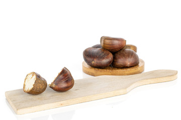 Wall Mural - Group of five whole two halves of edible brown chestnuts on coaster and cutting board isolated on white background