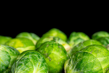 Wall Mural - Lot of whole fresh green brussels sprout isolated on black glass