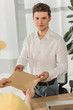 © LIGHTFIELD STUDIOS - Selective focus of businessman looking at camera while holding envelope near courier