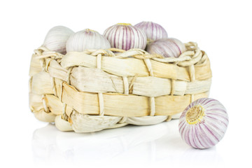 Wall Mural - Lot of whole fresh purple single clove garlic in bast basket isolated on white background