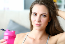 Beautiful Girl Holds Sports Water Bottle, Training. Home Fitness Is Key Element In Weight Loss Program. Close-up Girl Drinks Water For Physical Activity And Stamina During Training.