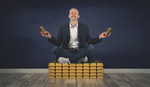 Relaxed Businessman Sits On A Stack Of Gold Bars