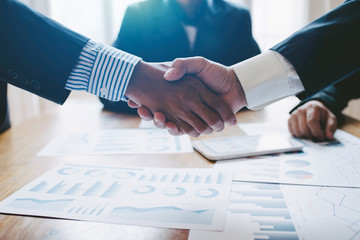 Young man business people shaking hands after brief job for contract signing in modern office with vintage picture style, colleagues at meeting teamwork of partnership.