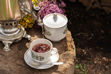 Fototapeta Kuchnia - Tea Cermonia with a Russian samovar. Traveling in Russia. Herbal drink. Alternative medicine Village lifestyle, fresh air and outdoor activities