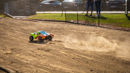 RC shortcourse going down the main straight and leaving dust trail behind