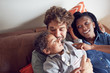 © Trevor Adeline/Caia Image - Affectionate young family cuddling on sofa