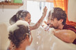 © Trevor Adeline/Caia Image - Playful daughters in bubble bath wiping bubbles on father‚Äôs face