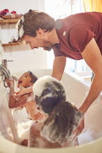 Playful Father Giving Daughters Bubble Bath