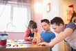 © Sam Edwards/Caia Image - Boy with Down Syndrome and siblings playing with toys at table