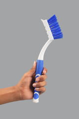 human hand holding plastic cleaning brush for cleaning