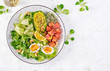 Ketogenic diet breakfast. Salt salmon salad with greens, cucumbers, eggs and avocado. Keto/paleo lunch. Top view, overhead
