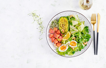 Ketogenic diet breakfast. Salt salmon salad with greens, cucumbers, eggs and avocado. Keto/paleo lunch. Top view, overhead