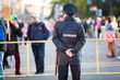 Police officer is on guard at the Victory Day celebration in the World War II. Rear view. Saint-Petersburg, Russia. Text is on back in Russian: police