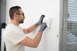 © W PRODUCTION - handsome man worker installing alarm technology insurance in home for burglar prevention