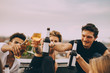 © Maskot - Friends celebrating with beer while enjoying in rooftop party at city
