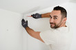 © W PRODUCTION - handsome man worker installing alarm technology insurance in home for burglar prevention
