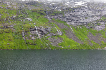 snow mountains in norwegian fiord reflection in water selective focus