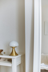 gold lamp white mirror white table in cozy scandinavian interior