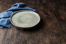 Empty Plate And Blue Towel Over Wooden Table