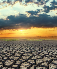 Poster - orange sunset over drought land. global warming concept