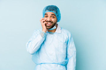 Wall Mural - Young surgeon latin man isolated Young dbiting fingernails, nervous and very anxious.