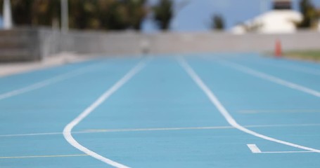 Wall Mural - Sprinter runner athlete man sprinting training on outdoor athletics track and field running lanes at stadium. Sport and health active lifestyle on college. SLOW MOTION 59.94 FPS.