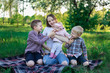 © somemeans - Young mother having picnic in nature with three children. Concept candid happy family