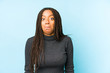 © Asier - Young african american woman isolated on blue background shrugs shoulders and open eyes confused.