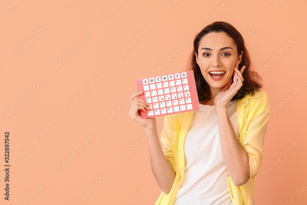 Young woman with menstrual calendar on color background