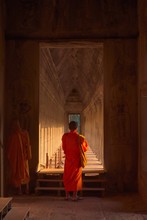 Buddhist Monk At Angkor Wat, Wearing Traditional Saffron Colored Robes, Standing On One If The Inner Galleries.