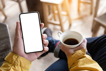 Mockup image blank white screen cell phone.man hand holding texting using mobile on desk at coffee shop.background empty space for advertise text.people contact marketing business,technology