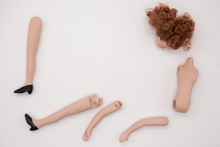 Broken Doll Body Parts On White Background