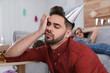 © New Africa - Young man with festive cap sleeping at table after party