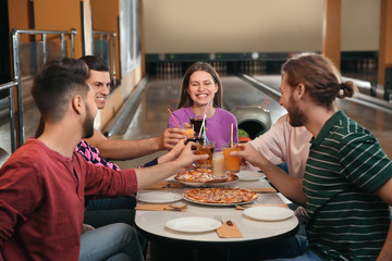 Wall Mural - Group of friends with drinks and pizza in bowling club