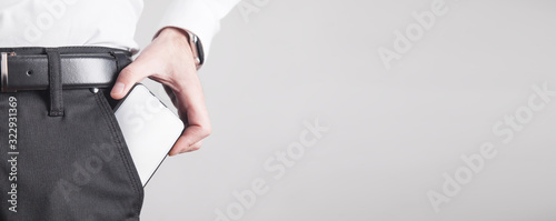 Fotografía Man putting smartphone in pocket of trousers.