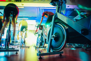 Wall Mural - Spinning class, group activity on stationary bike. Team cardio excercise on bicycle.