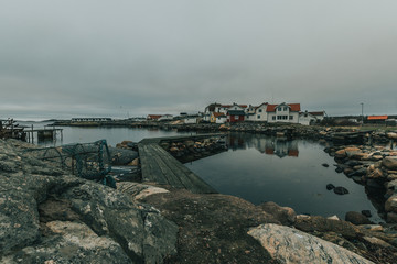 Vrångö, Southern Gothenburg Archipelago / Sweden -  A view of sea shore, a rocky landscape of Vrångö island and its scandinavian wooden houses in Sweden during a cloudy day.