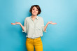 Photo of pretty lady raise hands shrug shoulders do not care friends problems ignoring smile wear casual green shirt yellow trousers isolated blue color background