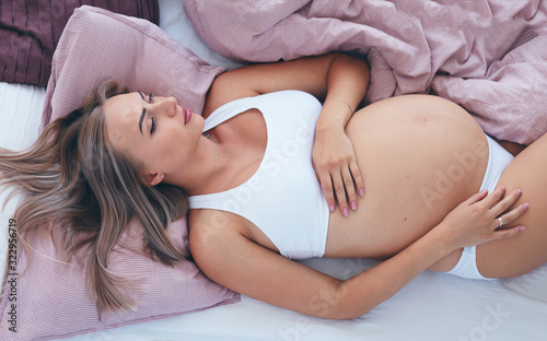 Cuadros en Lienzo young pregnant woman relaxing in bed in the morning