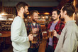 © Studio Romantic - Group of happy friends clinking glasses with beer at a sports bar.