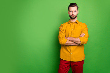 Sticker - Photo of amazing young business man bossy crossed arms not satisfied colleagues late work strict chief wear yellow shirt red pants isolated green color background