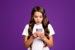© deagreez - Close-up portrait of her she nice attractive lovely cute astonished wavy-haired girl using device 5g app browsing comment isolated on bright vivid shine vibrant purple violet lilac color background