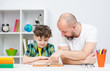 © Ermolaev Alexandr - Father and his son doing homework together at home