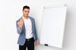 © luismolinero - Young caucasian handsome man isolated on purple background giving a presentation on white board and inviting to come with hand