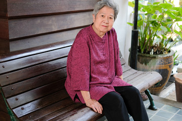 Wall Mural - old elder woman resting in garden. elderly female relaxing in park. senior leisure lifestyle