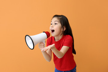 Cute little girl with megaphone on color background