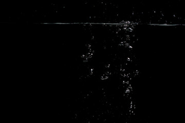  something falls into the water and causes seething and air bubbles on a black background for installation