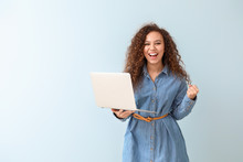 Happy African-American Woman With Laptop On Color Background